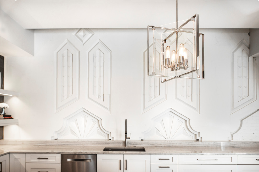 Inspiration for a large transitional medium tone wood floor and brown floor open concept kitchen remodel with an undermount sink, recessed-panel cabinets, white cabinets, quartzite countertops, brown backsplash, ceramic backsplash, stainless steel appliances, an island and white countertops