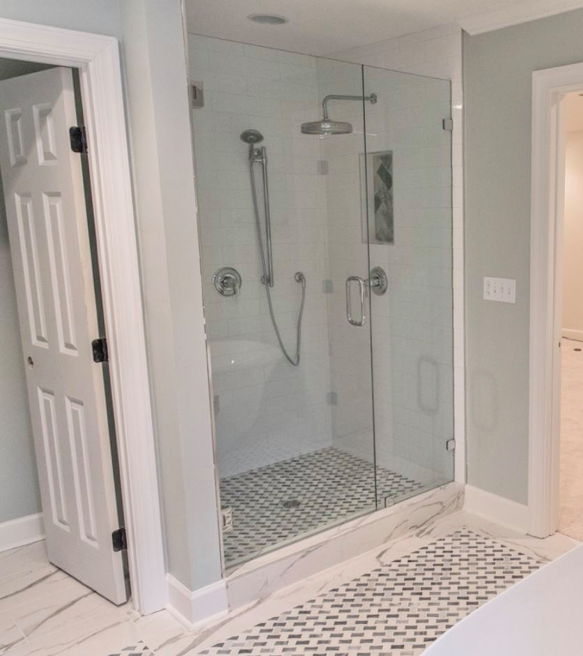 Mid-sized transitional master bathroom in Charlotte with furniture-like cabinets, white cabinets, a freestanding tub, an alcove shower, a two-piece toilet, white tile, porcelain tile, green walls, terra-cotta floors, an undermount sink, marble benchtops, white floor, a hinged shower door and white benchtops.