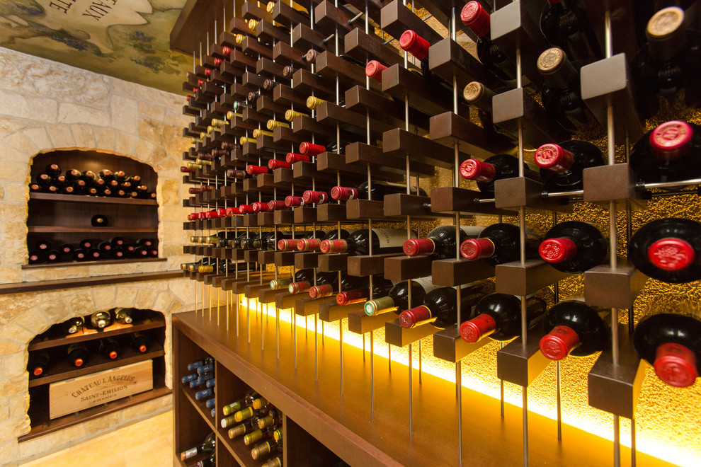 Photo of an expansive mediterranean wine cellar in Boston with limestone floors, storage racks and beige floor.