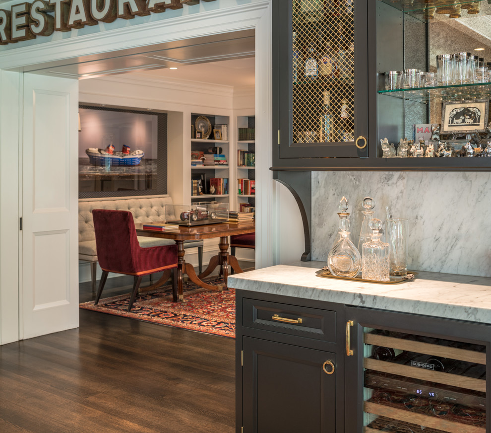 Small traditional single-wall wet bar in Wilmington with an undermount sink, recessed-panel cabinets, black cabinets, marble benchtops, white splashback, marble splashback, dark hardwood floors, brown floor and white benchtop.