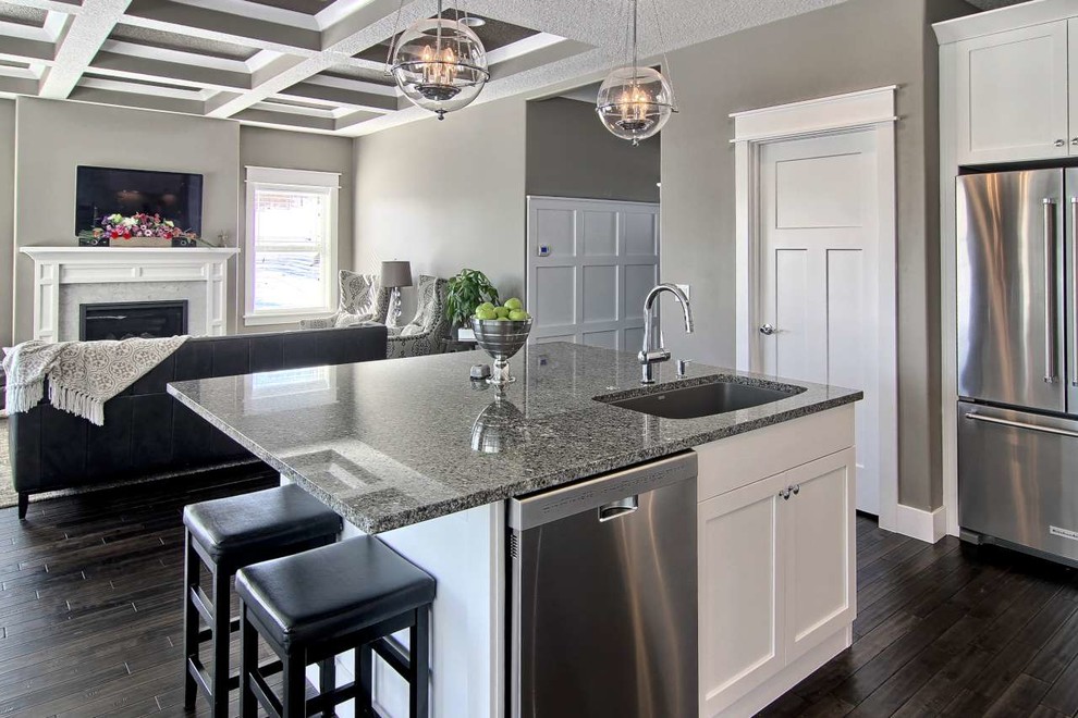 Inspiration for a mid-sized transitional l-shaped dark wood floor open concept kitchen remodel with a single-bowl sink, shaker cabinets, white cabinets, granite countertops, gray backsplash, stone tile backsplash, stainless steel appliances and an island