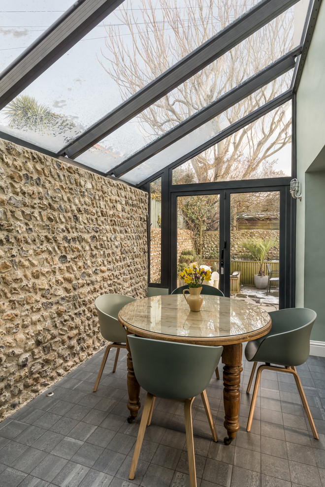 Design ideas for a transitional dining room in Sussex with green walls and grey floor.