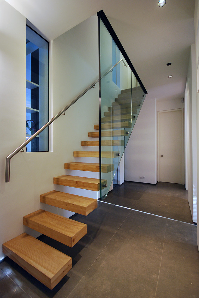 Large contemporary wood floating staircase in London with open risers.
