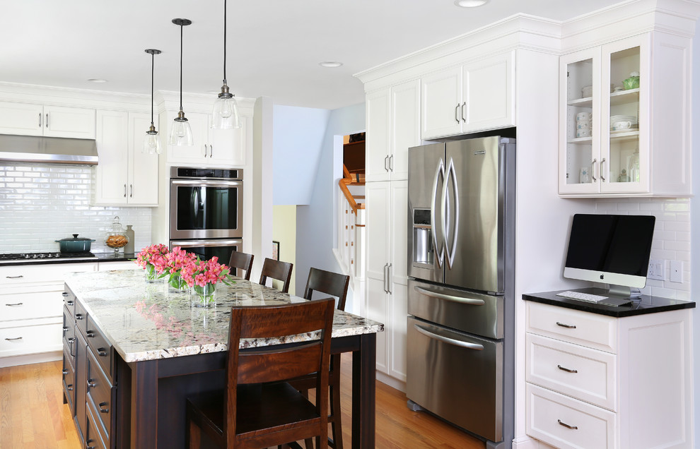 Inspiration for a mid-sized craftsman l-shaped light wood floor eat-in kitchen remodel in Chicago with an undermount sink, white cabinets, granite countertops, white backsplash, subway tile backsplash, stainless steel appliances and an island