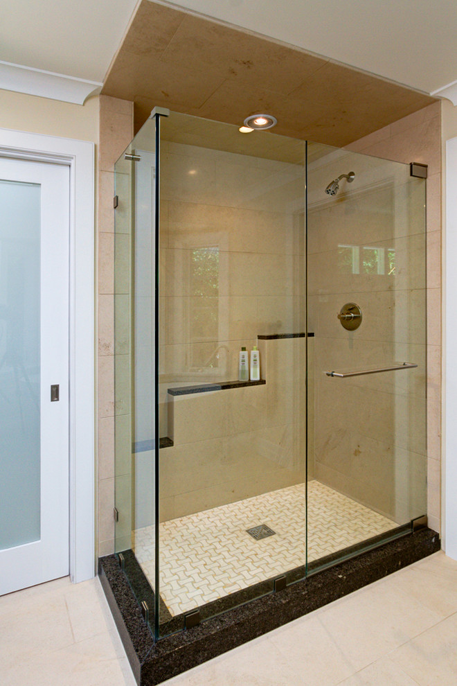 This is an example of a transitional bathroom in Los Angeles with a corner shower, beige walls, porcelain floors and a hinged shower door.