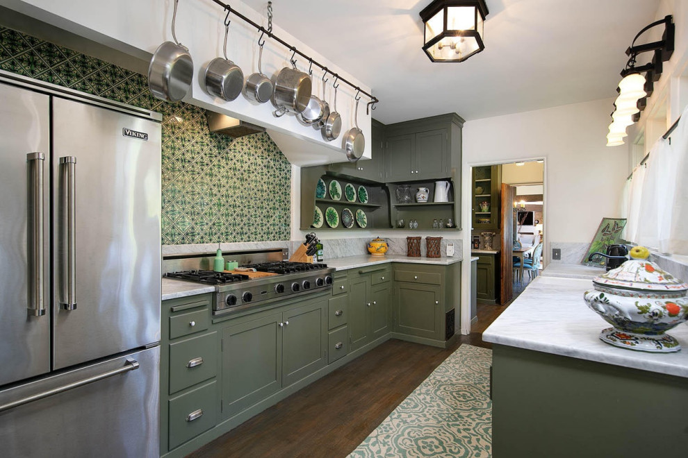 Inredning av ett avskilt, mellanstort vit vitt l-kök, med en rustik diskho, skåp i shakerstil, gröna skåp, marmorbänkskiva, grönt stänkskydd, stänkskydd i keramik, rostfria vitvaror, mörkt trägolv och brunt golv