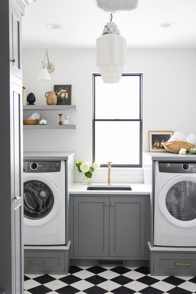 Inspiration for a large transitional laundry room in Other with an undermount sink, grey cabinets, quartz benchtops, white splashback, engineered quartz splashback, white walls, porcelain floors, an integrated washer and dryer and white benchtop.
