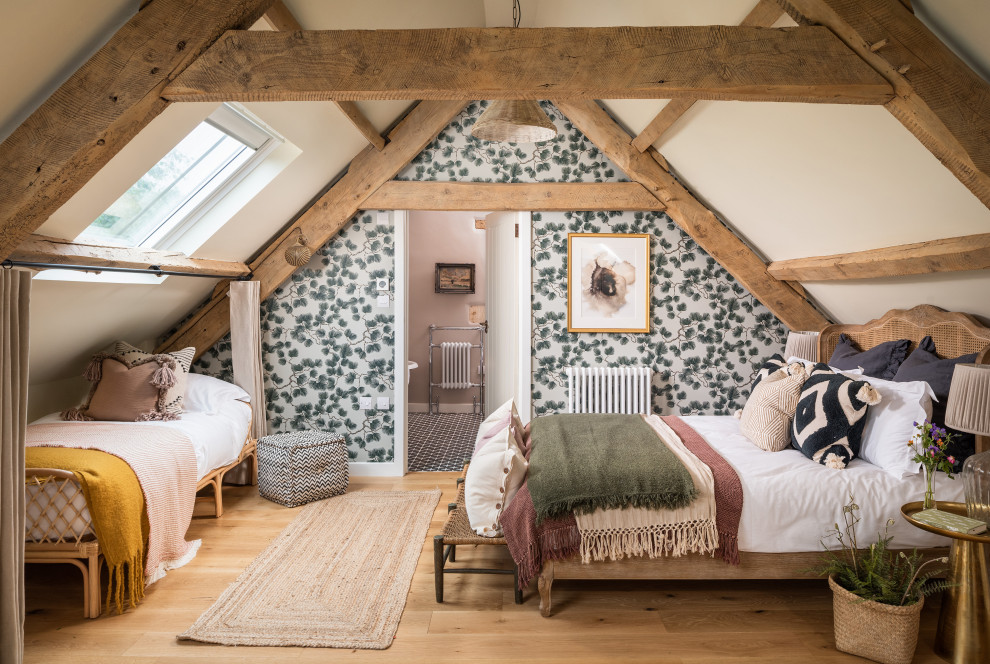 Inspiration for a large farmhouse bedroom in Gloucestershire with multi-coloured walls, medium hardwood flooring, brown floors and wallpapered walls.