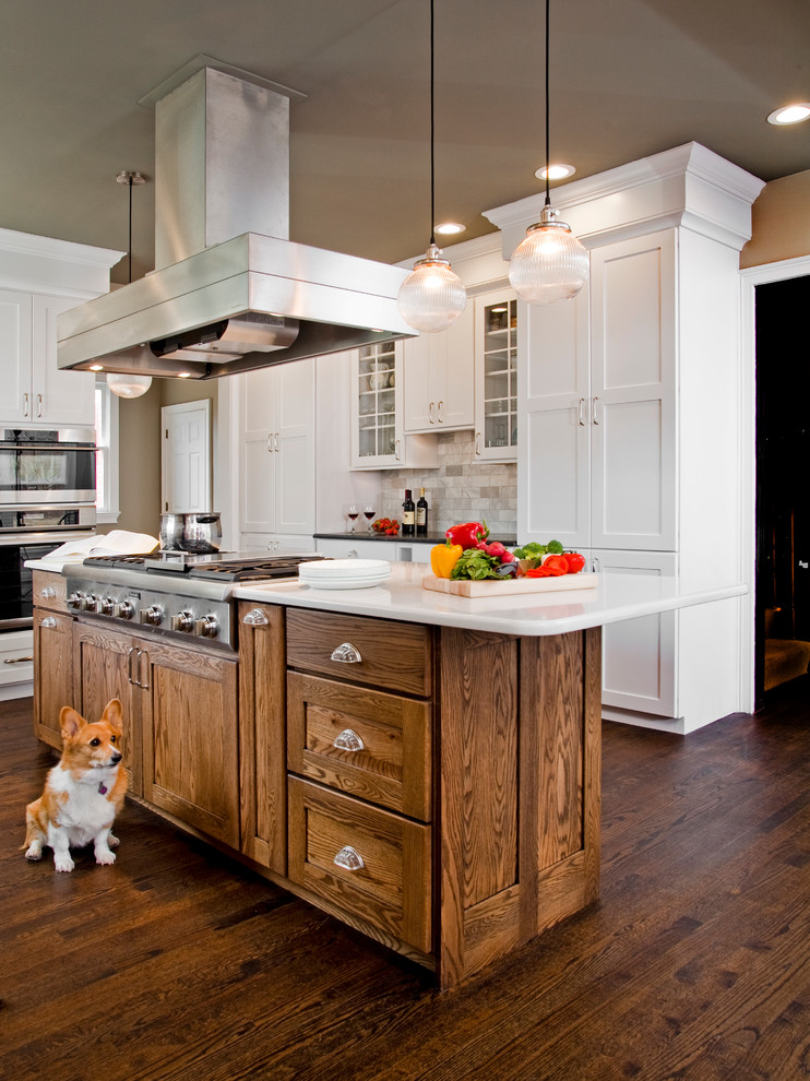 Eat-in kitchen - large transitional l-shaped medium tone wood floor eat-in kitchen idea in Philadelphia with a farmhouse sink, shaker cabinets, white cabinets, granite countertops, gray backsplash, stone tile backsplash, stainless steel appliances and an island