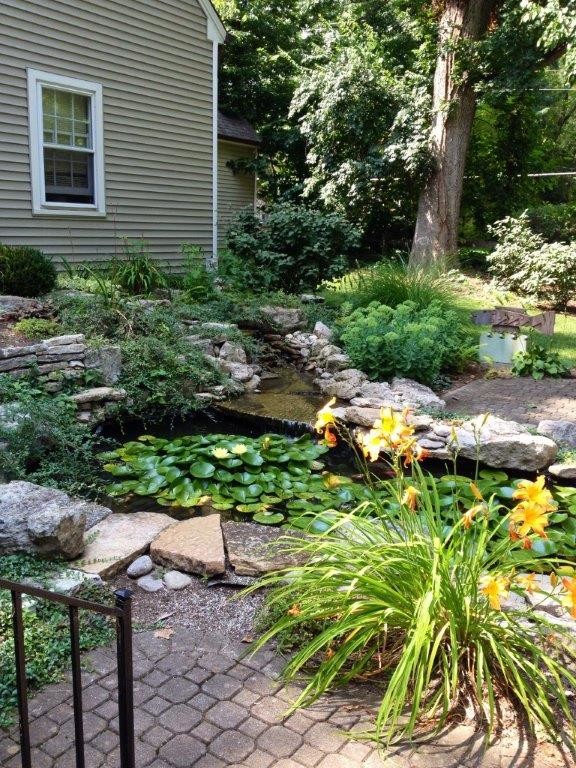 Photo of a mid-sized transitional full sun backyard stone landscaping in Cincinnati for spring.