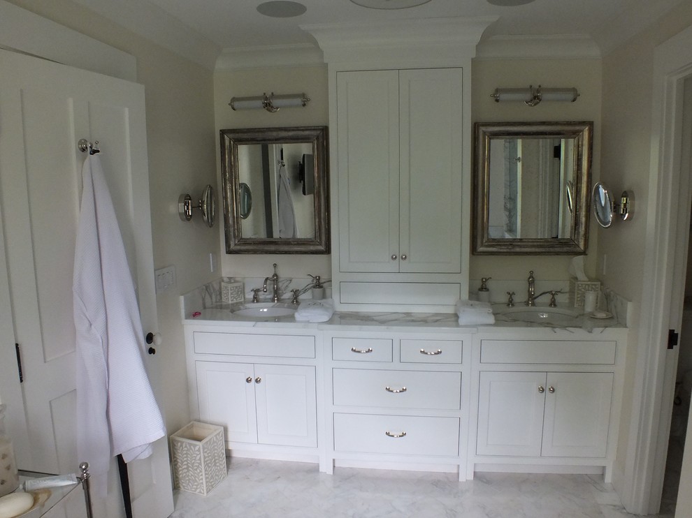 Design ideas for a mid-sized traditional master bathroom in New York with an undermount sink, shaker cabinets, white cabinets, marble benchtops, a freestanding tub, an alcove shower, a two-piece toilet, multi-coloured tile, stone tile, white walls and marble floors.