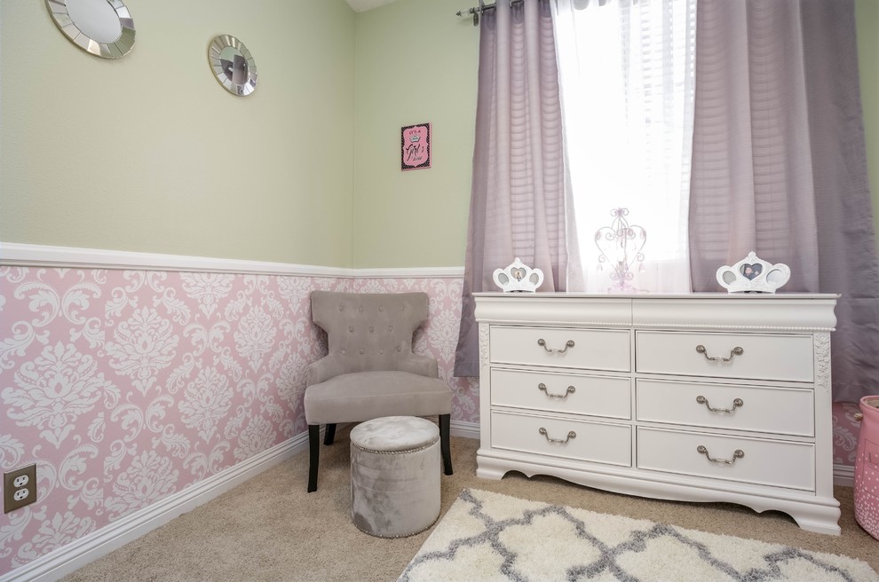 This is an example of a contemporary nursery for girls in Los Angeles with carpet, beige floor and green walls.