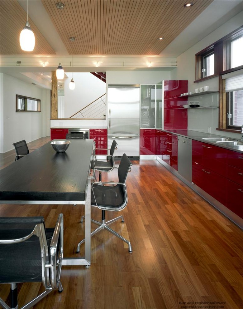 Photo of a modern l-shaped kitchen in Toronto with red cabinets, stainless steel benchtops, glass sheet splashback, stainless steel appliances, medium hardwood floors, no island, an integrated sink, flat-panel cabinets and white splashback.