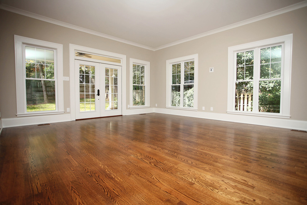 Design ideas for a large traditional open concept family room in Charlotte with medium hardwood floors and grey walls.