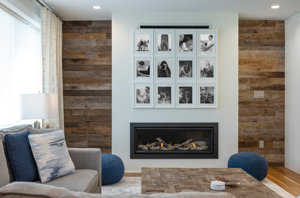 This is an example of a small transitional open concept family room in Vancouver with white walls, medium hardwood floors, a ribbon fireplace, a plaster fireplace surround and brown floor.