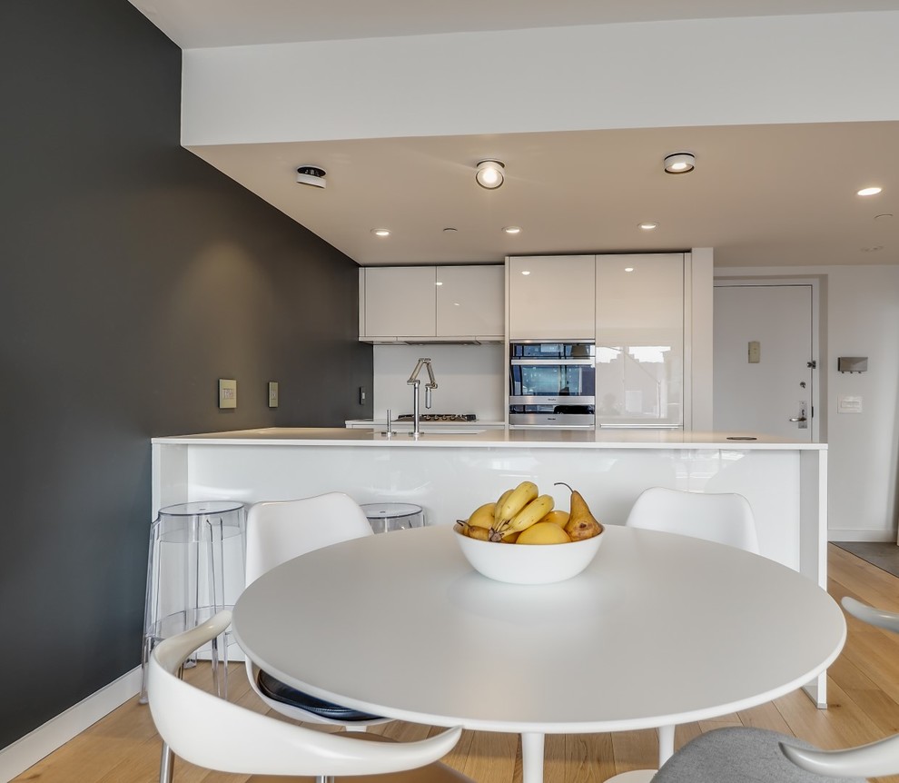 Small minimalist light wood floor kitchen/dining room combo photo in New York with black walls