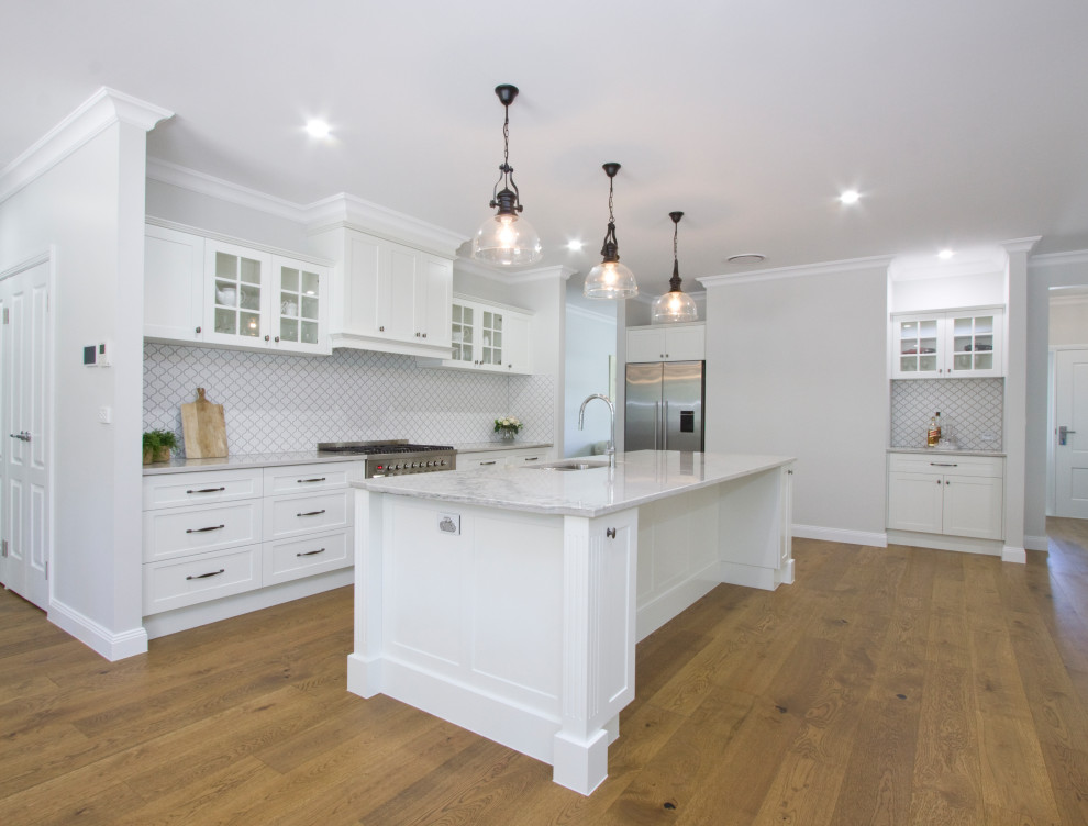 Design ideas for a large traditional open plan kitchen in Sunshine Coast with an undermount sink, shaker cabinets, white cabinets, quartzite benchtops, mosaic tile splashback, stainless steel appliances and with island.