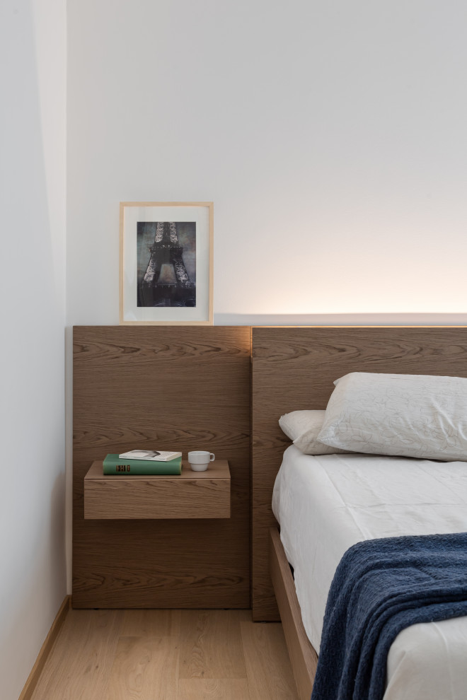 Diseño de dormitorio principal contemporáneo de tamaño medio con paredes blancas, suelo de madera pintada, suelo beige y boiserie