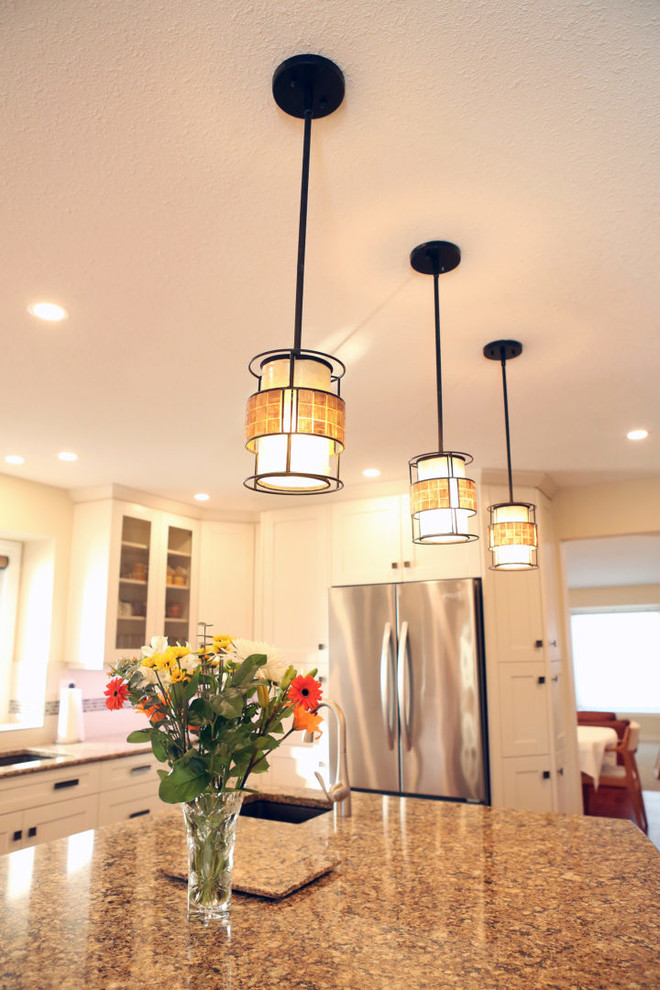 Inspiration for a mid-sized transitional l-shaped medium tone wood floor and brown floor open concept kitchen remodel in Calgary with an undermount sink, shaker cabinets, white cabinets, granite countertops, white backsplash, mosaic tile backsplash, stainless steel appliances, an island and beige countertops