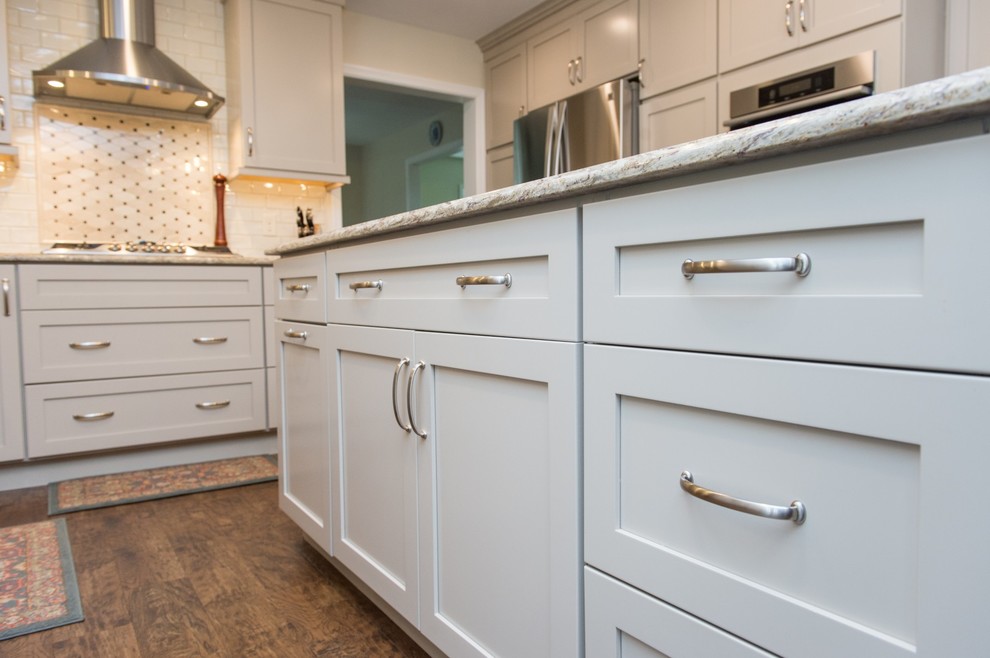 Eat-in kitchen - transitional u-shaped vinyl floor and brown floor eat-in kitchen idea with an undermount sink, shaker cabinets, quartz countertops, subway tile backsplash, stainless steel appliances and an island