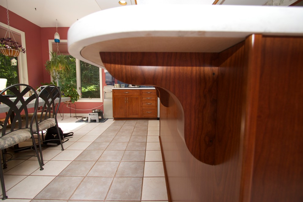 Open concept kitchen - transitional l-shaped ceramic tile open concept kitchen idea in Baltimore with an undermount sink, recessed-panel cabinets, medium tone wood cabinets, solid surface countertops, blue backsplash, ceramic backsplash, stainless steel appliances and an island