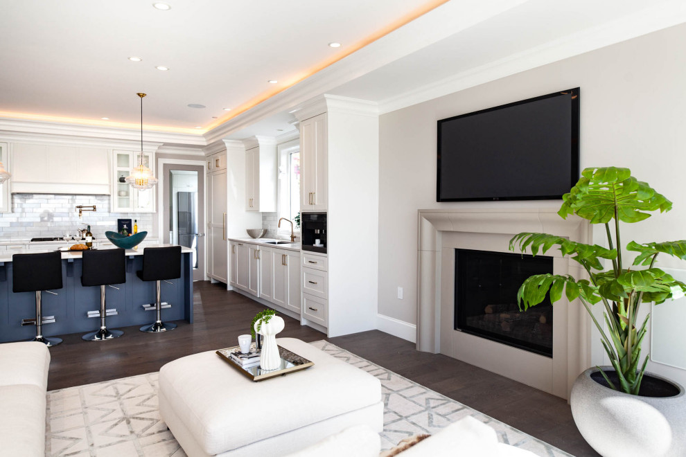 This is an example of an expansive classic open plan games room in Vancouver with grey walls, medium hardwood flooring, a standard fireplace, a concrete fireplace surround, a wall mounted tv, grey floors and a coffered ceiling.