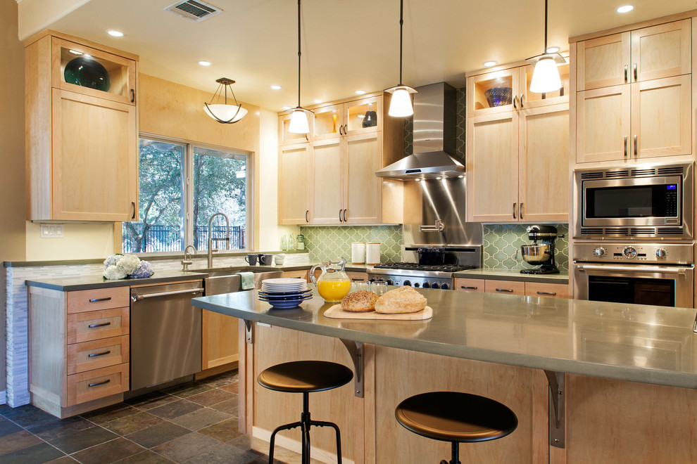 Inspiration for a mid-sized transitional l-shaped slate floor eat-in kitchen remodel in Austin with an undermount sink, recessed-panel cabinets, light wood cabinets, green backsplash, stainless steel appliances and an island