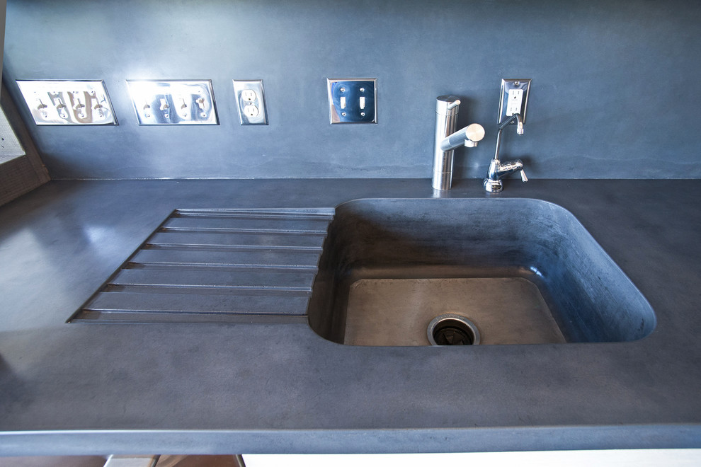 Mountain style home design photo with an integrated sink, concrete countertops, gray backsplash and cement tile backsplash