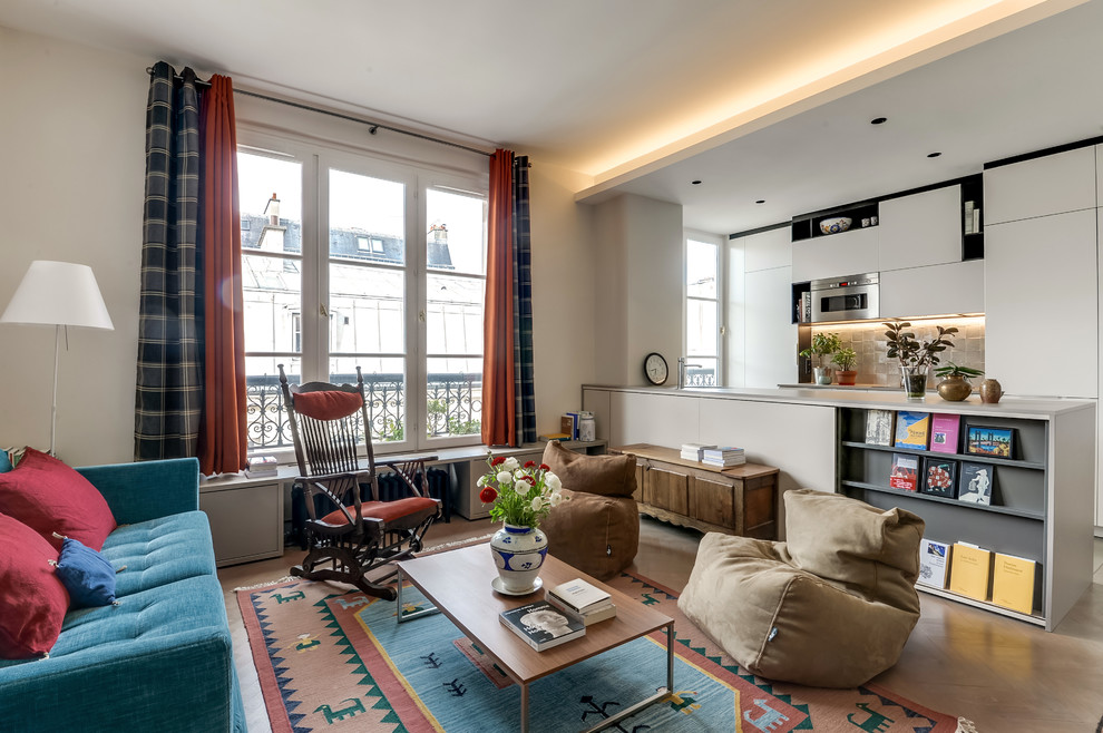 Photo of a large eclectic open concept living room in Paris with white walls, light hardwood floors, no fireplace and no tv.