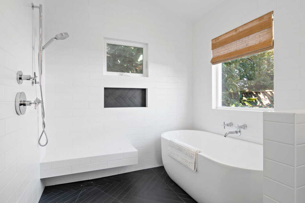 Photo of a large transitional master wet room bathroom in Los Angeles with furniture-like cabinets, brown cabinets, a freestanding tub, white tile, subway tile, porcelain floors, engineered quartz benchtops, black floor, a hinged shower door and white benchtops.
