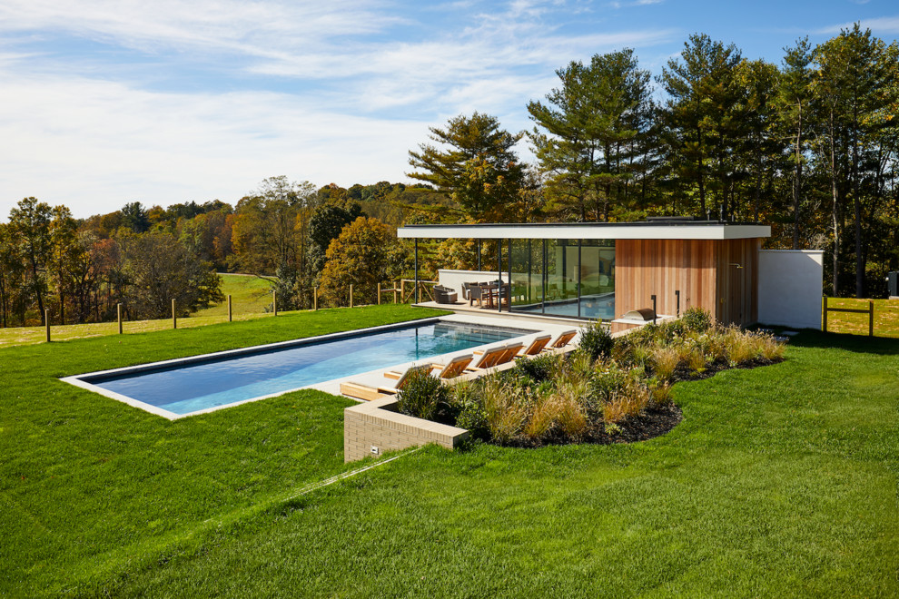 This is an example of a midcentury rectangular pool in New York with a pool house.