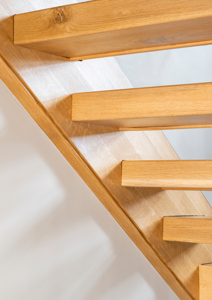 На фото: большая п-образная лестница в современном стиле с деревянными ступенями и металлическими перилами без подступенок
