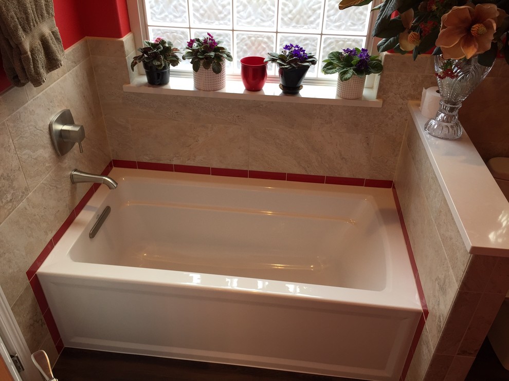 Design ideas for a mid-sized transitional bathroom in Seattle with beige tile, porcelain tile, an alcove shower, a two-piece toilet and red walls.