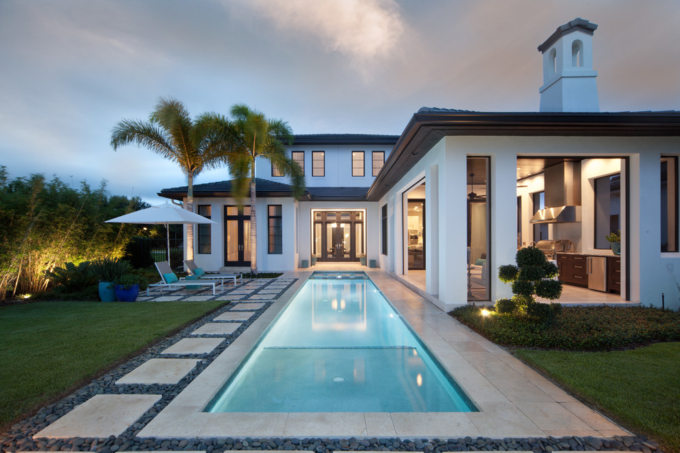 This is an example of a large transitional backyard rectangular lap pool in Orlando with a pool house.