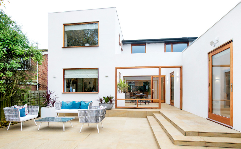 Mid-sized contemporary backyard patio in Hertfordshire with natural stone pavers.