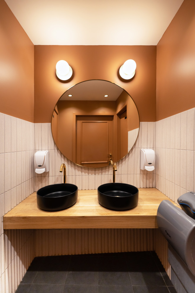 Ispirazione per un bagno di servizio moderno con pareti arancioni, lavabo da incasso e pavimento nero