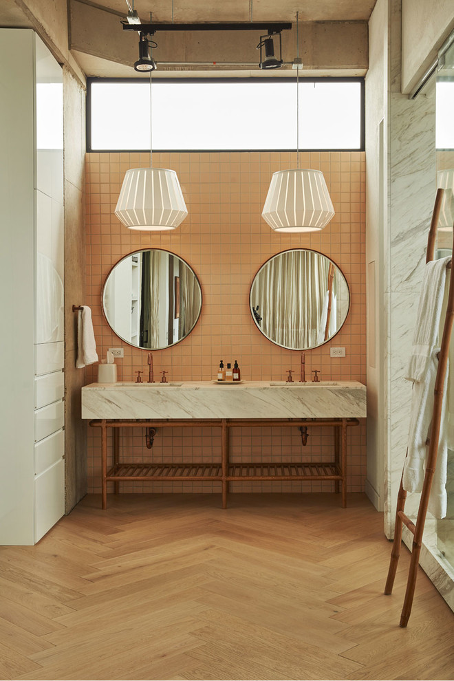 Inspiration for a large midcentury master bathroom in Minneapolis with a freestanding tub, a shower/bathtub combo, pink tile, ceramic tile, pink walls, medium hardwood floors, a drop-in sink, brown floor, a hinged shower door and grey benchtops.