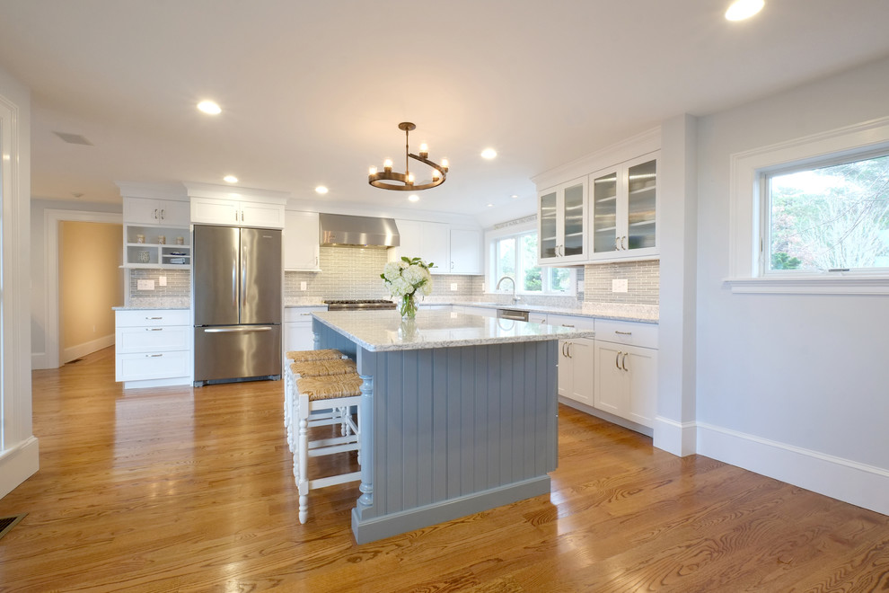 Inspiration for a beach style kitchen in Boston with a single-bowl sink, shaker cabinets, white cabinets, quartz benchtops, blue splashback, glass tile splashback, stainless steel appliances, medium hardwood floors and with island.