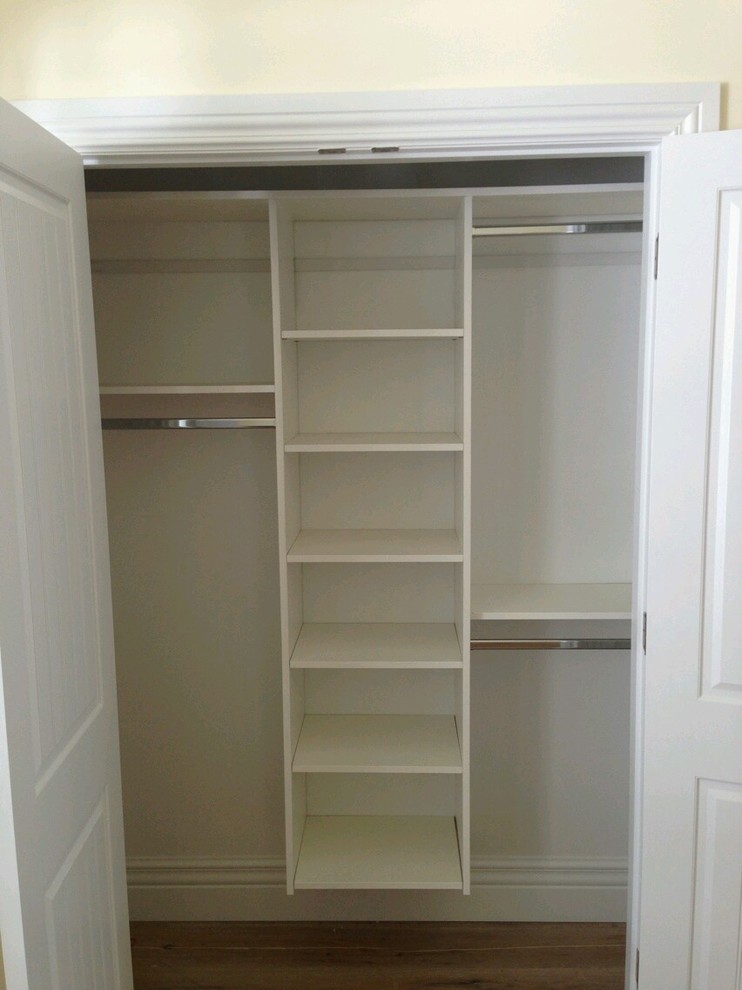 Mid-sized traditional gender-neutral walk-in wardrobe in Salt Lake City with white cabinets, open cabinets and dark hardwood floors.