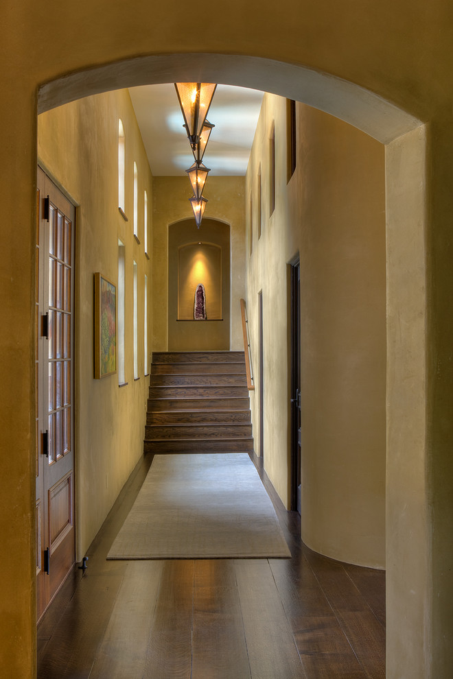 Photo of a mediterranean hallway in Cincinnati with beige walls and dark hardwood floors.