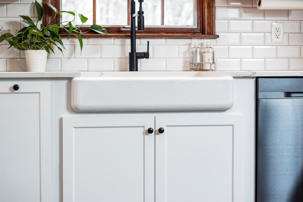 Example of a large transitional u-shaped eat-in kitchen design in Columbus with shaker cabinets, quartz countertops, white backsplash and an island