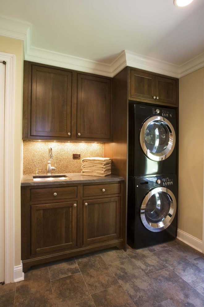 Photo of a traditional laundry room in New York with a stacked washer and dryer and grey benchtop.