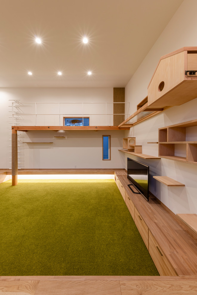 Inspiration för mellanstora minimalistiska allrum med öppen planlösning, med vita väggar, heltäckningsmatta, en fristående TV och grönt golv