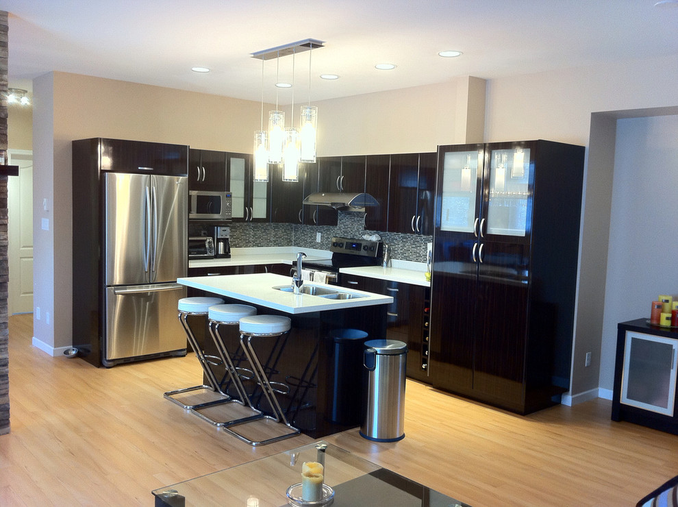 Mid-sized transitional galley dark wood floor kitchen photo in Vancouver with a drop-in sink, recessed-panel cabinets, white cabinets, marble countertops, gray backsplash, ceramic backsplash, stainless steel appliances and an island