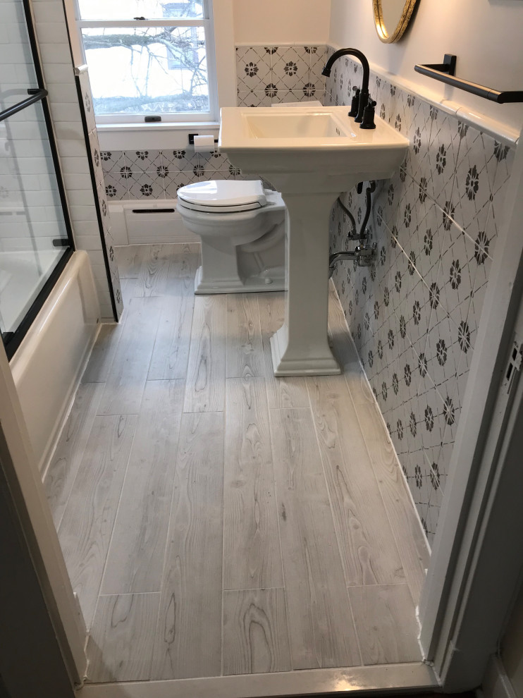 Photo of a small traditional family bathroom in Baltimore with an alcove bath, an alcove shower, a two-piece toilet, black and white tiles, ceramic tiles, grey walls, ceramic flooring, a pedestal sink, grey floors, a sliding door, a wall niche and a single sink.