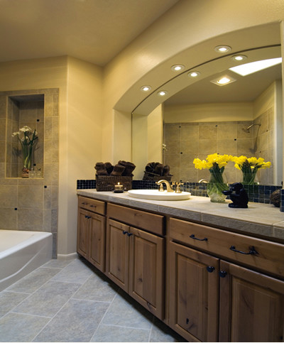 Photo of a large master bathroom in Albuquerque with raised-panel cabinets, medium wood cabinets, an alcove tub, a two-piece toilet, beige tile, black tile, mosaic tile, beige walls, slate floors, a drop-in sink, concrete benchtops and grey floor.