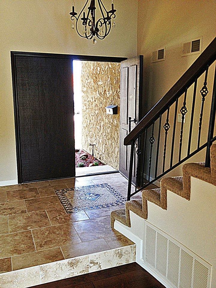 This is an example of a traditional entryway in San Diego with a double front door and a dark wood front door.