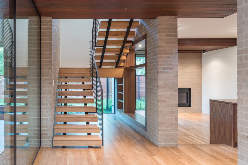 Inspiration for a mid-sized modern wood u-shaped staircase in Houston with open risers and metal railing.