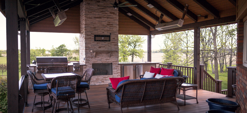 Inspiration for a huge rustic backyard outdoor kitchen deck remodel in Indianapolis with a roof extension