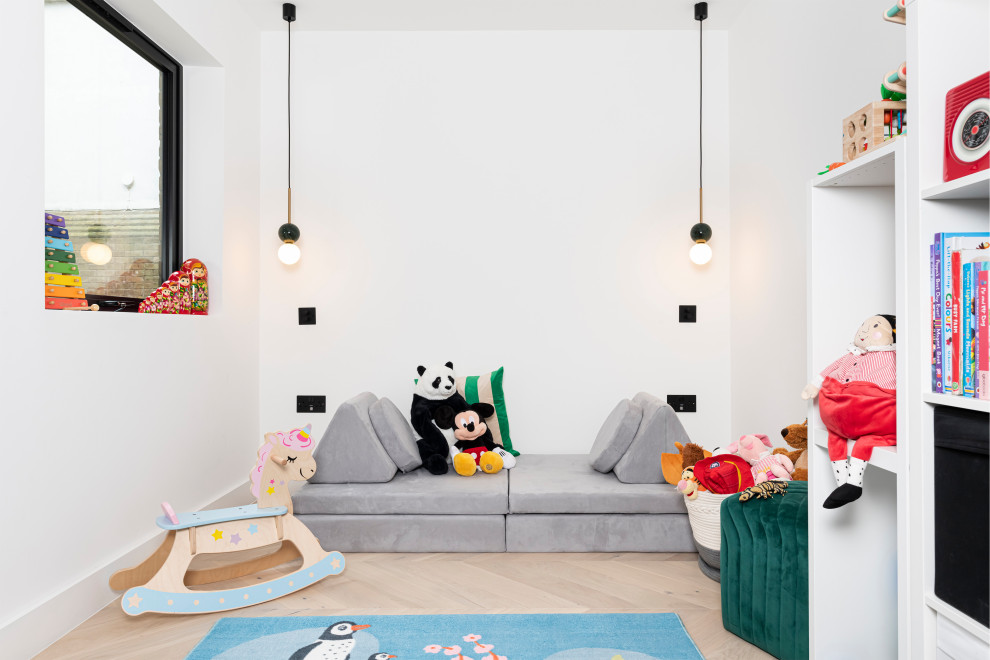 На фото: нейтральная комната для малыша среднего размера: освещение в современном стиле с белыми стенами и светлым паркетным полом